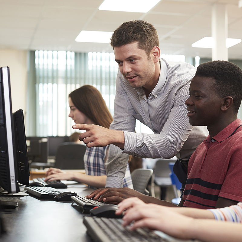 A teacher and two students using the Python in Pieces coding platform by 2Simple Ltd